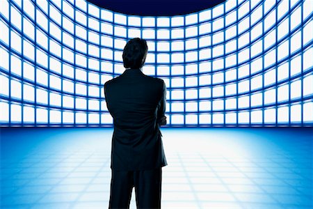 simsearch:670-06451367,k - Homme d'affaires regardant mur vidéo Photographie de stock - Rights-Managed, Code: 700-01109920