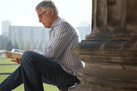 Man Sitting and Reading Book at Base of Column Foto de stock - Con derechos protegidos, Código: 700-01100209