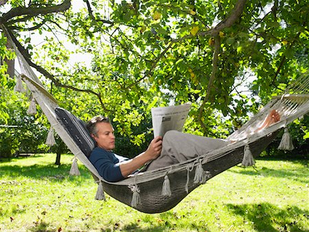Man Reading Paper in Hammock Stock Photo - Rights-Managed, Code: 700-01119836