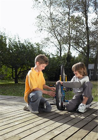 people on backyard deck - Boys Fixing Bike Foto de stock - Con derechos protegidos, Código: 700-01119874