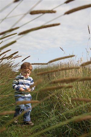simsearch:700-00910950,k - Boy Walking in Grass Field Foto de stock - Direito Controlado, Número: 700-01110286