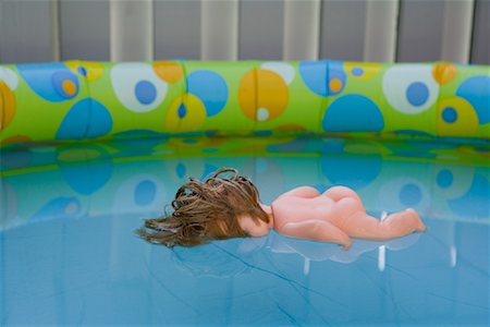 sventura - Doll Floating in Wading Pool Fotografie stock - Rights-Managed, Codice: 700-01124411
