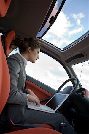 Femme d'affaires utilisant un ordinateur portable dans la voiture Photographie de stock - Rights-Managed, Code: 700-01164602