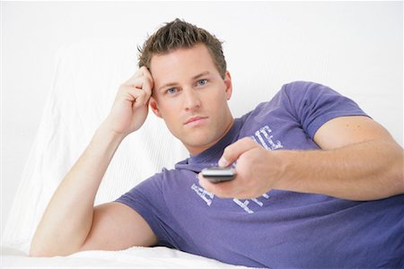 single man on the couch watching tv - Portrait of Man With Remote Control Stock Photo - Rights-Managed, Code: 700-01165035