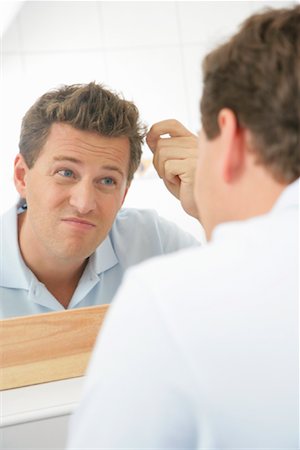 simsearch:700-00866702,k - Examinant les cheveux dans le miroir de l'homme Photographie de stock - Rights-Managed, Code: 700-01165121