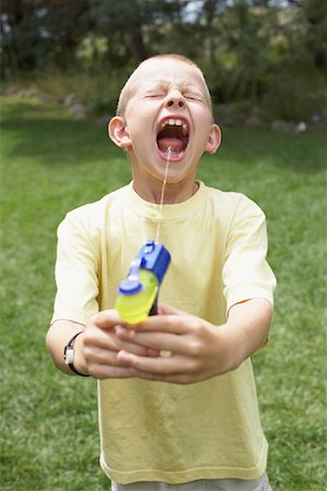 pistola de agua - Boy Playing With Water Gun Foto de stock - Con derechos protegidos, Código: 700-01163925