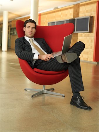 Man Sitting on Chair Using Laptop Computer Foto de stock - Direito Controlado, Número: 700-01173226