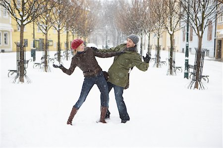 pelea de bolas de nieve - Couple Having a Snowball Fight Foto de stock - Con derechos protegidos, Código: 700-01185266
