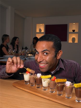 funny faces african american - Man Sneaking Food at Dinner Party Stock Photo - Rights-Managed, Code: 700-01183920