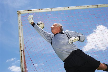 errar o alvo - Goalie Reaching for Soccer Ball Foto de stock - Direito Controlado, Número: 700-01199285