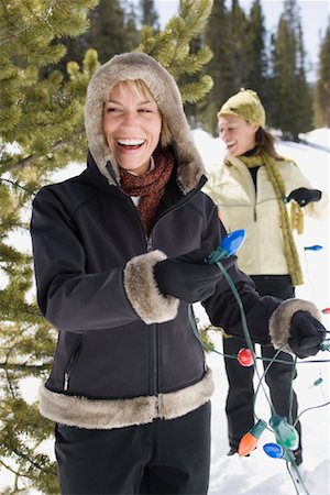 simsearch:700-01275975,k - Femmes de mettre des lumières de Noël sur l'arbre Photographie de stock - Rights-Managed, Code: 700-01199389