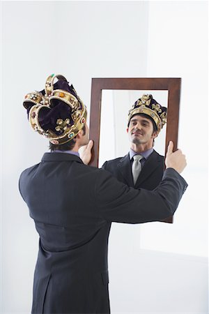 Homme d'affaires avec la Couronne en regardant dans le miroir Photographie de stock - Rights-Managed, Code: 700-01224048