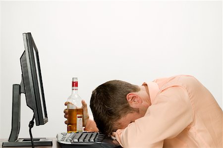 Homme d'affaires s'est évanoui à l'ordinateur après potable Photographie de stock - Rights-Managed, Code: 700-01223715