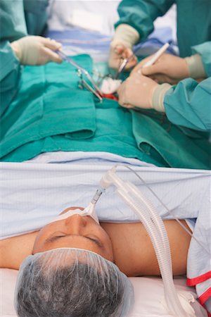 surgeon with bloody gloves - Doctors Performing Surgery Stock Photo - Rights-Managed, Code: 700-01234872