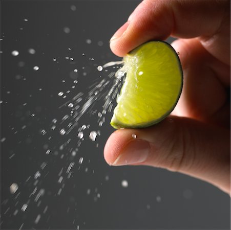 squeeze fruit - Hand Squeezing Lime Wedge Stock Photo - Rights-Managed, Code: 700-01236290