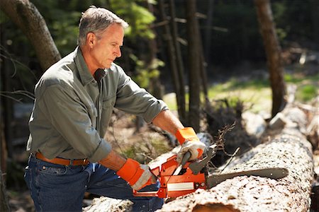 simsearch:400-04943114,k - Man Cutting Wood With Chainsaw Foto de stock - Con derechos protegidos, Código: 700-01236658