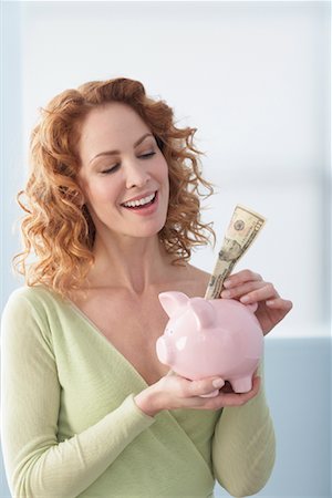 Woman Putting Cash in Piggy Bank Stock Photo - Rights-Managed, Code: 700-01260034