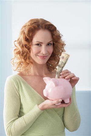 Woman Putting Cash in Piggy Bank Stock Photo - Rights-Managed, Code: 700-01260033