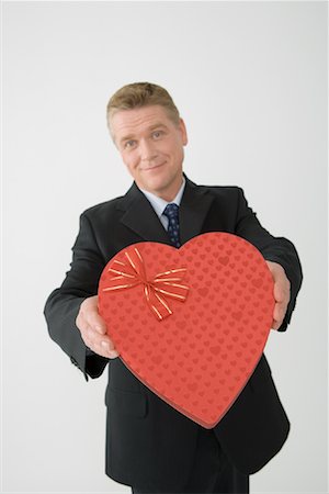 displaying chocolates - Businessman Holding Heart-Shaped Box Stock Photo - Rights-Managed, Code: 700-01275157