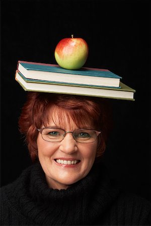 portrait of woman with fruit on head - Équilibrage de livres et pomme sur la tête de femme Photographie de stock - Rights-Managed, Code: 700-01296562