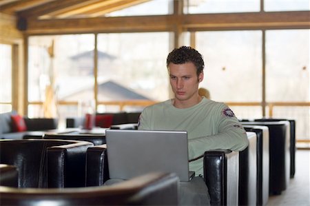 romance por internet - Man Using Laptop in Lounge Foto de stock - Con derechos protegidos, Código: 700-01344858