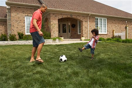 picture of father and son playing foot ball - Father and Son Playing Soccer Foto de stock - Con derechos protegidos, Código: 700-01494591