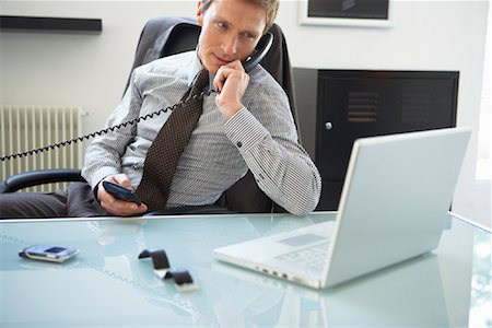 francés (hombre) - Businessman Talking on Phone, Looking at Laptop Computer Foto de stock - Con derechos protegidos, Código: 700-01494650