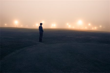 einzelgänger (männlich) - Person steht im beleuchteten Golfplatz, Edinburgh, Midlothian, Schottland, UK Stockbilder - Lizenzpflichtiges, Bildnummer: 700-01538868