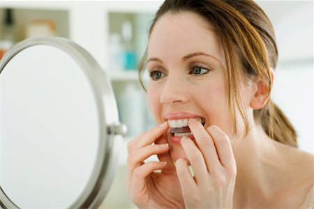 Woman Applying Whitener Strip to Teeth Stock Photo - Rights-Managed, Code: 700-01541099