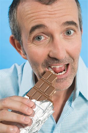 Portrait of Man Eating Chocolate Bar Foto de stock - Con derechos protegidos, Código: 700-01586264