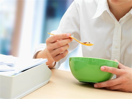 schreibtischablage - Businesswoman Eating Cereal Foto de stock - Con derechos protegidos, Código: 700-01587491