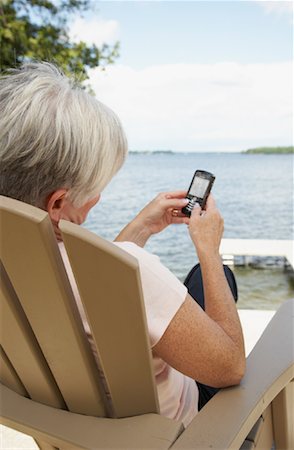 senior women chat - Woman at the Cottage, Reading Text Message Stock Photo - Rights-Managed, Code: 700-01615219