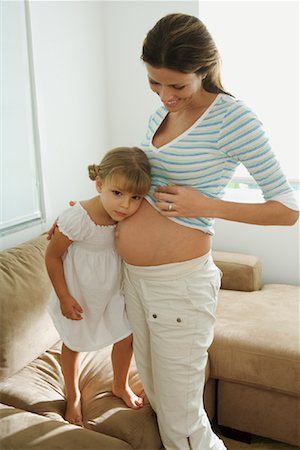 stomach sitting on moms - Girl Listening to Pregnant Mother's Belly Stock Photo - Rights-Managed, Code: 700-01646277