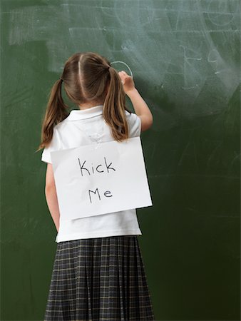 Girl Writing on Blackboard with Sign on Back Stock Photo - Rights-Managed, Code: 700-01646364