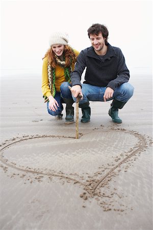 Couple Drawing Heart in Sand, Ireland Foto de stock - Con derechos protegidos, Código: 700-01694882
