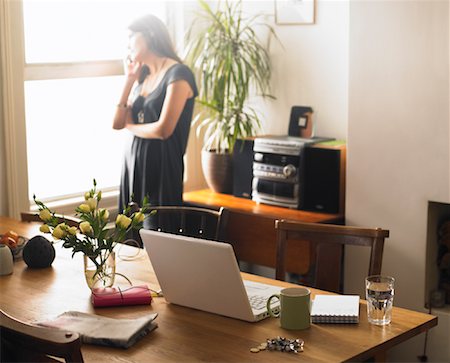 still life phone - Laptop Computer on Table with Woman using Cell Phone in Background Stock Photo - Rights-Managed, Code: 700-01742742