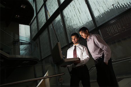 Les hommes d'affaires à la recherche à l'intérieur de la mallette rougeoyante Photographie de stock - Rights-Managed, Code: 700-01764286