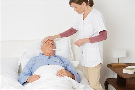 elderly person with caregiver at home - Nurse Taking Patient's Temperature Foto de stock - Con derechos protegidos, Código: 700-01764481