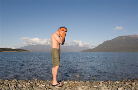 southland - Man Drying Face by Lake, Lake Te Anau, Fiordland National Park, South Island, New Zealand Foto de stock - Con derechos protegidos, Código: 700-01765175