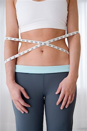 Woman's Stomach Wrapped with Measuring Tape Foto de stock - Con derechos protegidos, Código: 700-01787595