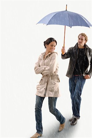 Man Holding Umbrella Over Woman in the Rain Fotografie stock - Rights-Managed, Codice: 700-01792437