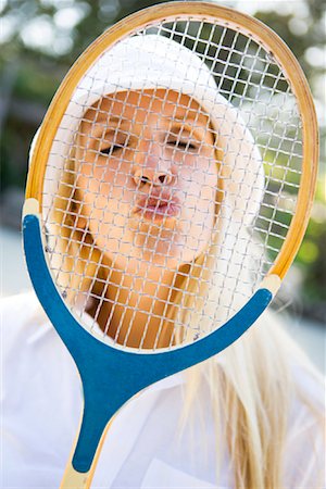 Woman Blowing Kisses Through Tennis Racquet Foto de stock - Con derechos protegidos, Código: 700-01837405