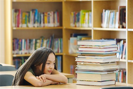 Student in Library, Looking at Stack of Books Stock Photo - Rights-Managed, Code: 700-01954514