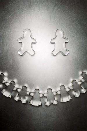 Two Gingerbread Men Cookie Cutters with Semicircle of Others Stock Photo - Rights-Managed, Code: 700-01955418