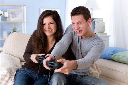 Boyfriend and girlfriend playing video games with controller on console  Stock Photo by ©DragosCondreaW 564191710