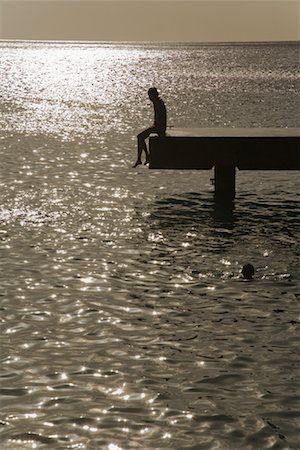 silhouette people sitting on a dock - Person Sitting on Edge of Dock, Bonaire, Netherlands Antilles Foto de stock - Con derechos protegidos, Código: 700-01993337