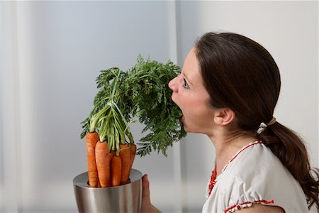 Femme mangeant verdure de botte de carottes Photographie de stock - Rights-Managed, Code: 700-02010071