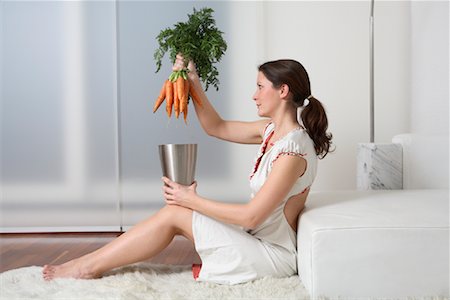 Femme assise sur le plancher, placer des tas de carottes dans le récipient Photographie de stock - Rights-Managed, Code: 700-02010073