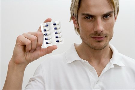 simsearch:625-02932810,k - Portrait of Man Holding Pills Fotografie stock - Rights-Managed, Codice: 700-02033915