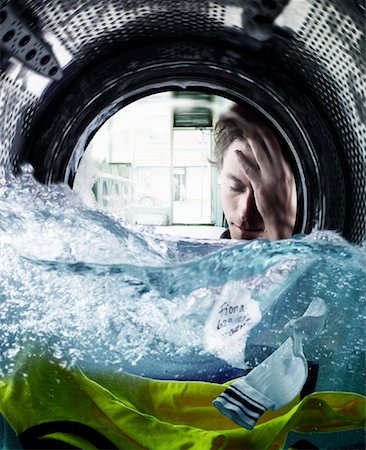 funny depressed - Man Looking at Piece of Paper in Washing Machine Stock Photo - Rights-Managed, Code: 700-02066112